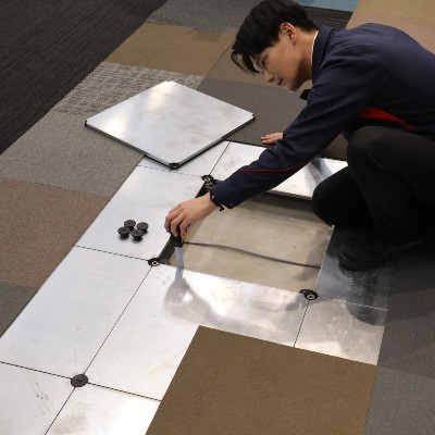 すクルードライバーで柱を止めている作業着の男性